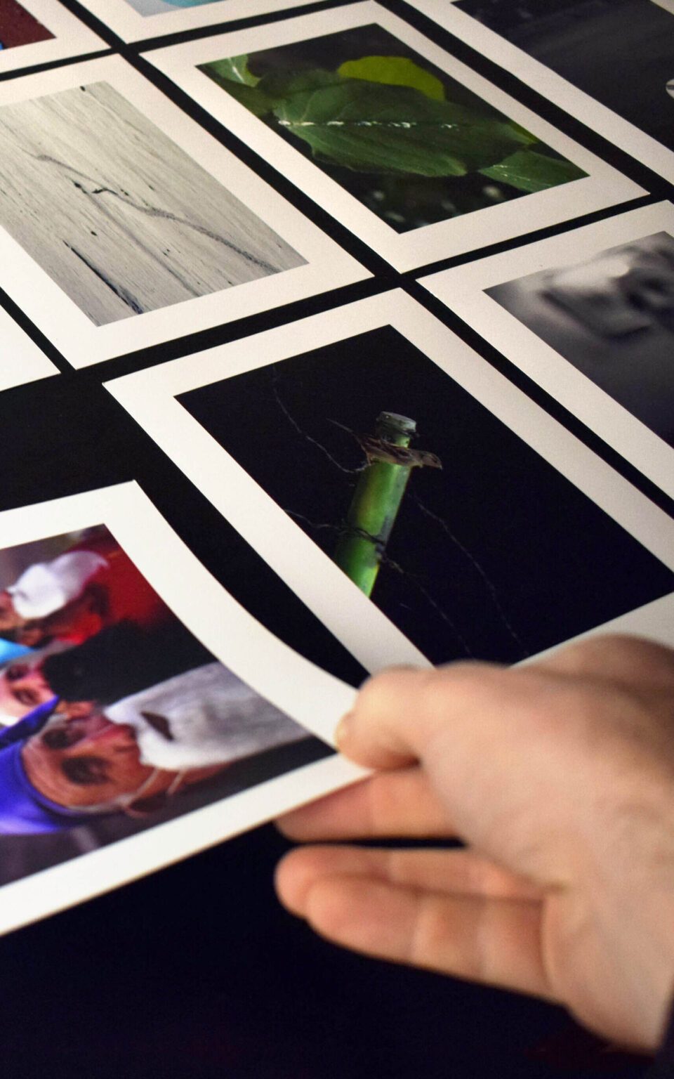 Una mano levanta una fotografía impresa entre otras copias dispuestas sobre una mesa durante un curso